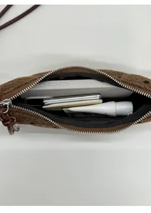 Vista interna della borsa marrone con spazio per cellulare e prodotti di bellezza