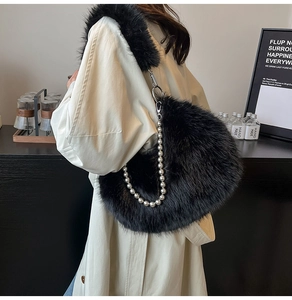 Détail d'un sac à bandoulière en fausse fourrure noire avec chaîne perlée et texture douce