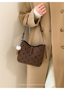 Close-up of retro polka dot crossbody bag with bow embroidery and plush charm