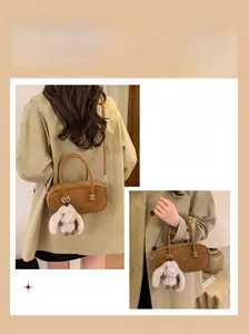 Brown vintage Boston bag detail with plush rabbit charm and versatile shoulder strap options