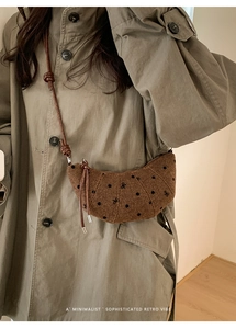 Dettaglio della borsa a mezzaluna in tweed marrone con pois neri e ricamo a fiocco