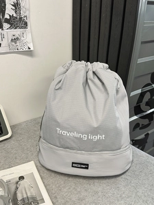 Zaino grigio chiaro con coulisse, stampa Traveling Light e scomparto inferiore con zip