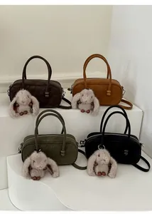 Detailed display of four leather Boston bags in coffee, brown, green and black with charms