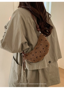 Détail du sac croissant marron avec pois et broderie nœud sur un trench vert olive