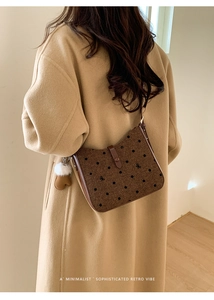 Polka dot tweed bucket bag with heart charm shown on model's shoulder in retro style
