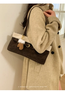 Detail of suede tote bag with faux shearling trim and decorative glove charm on model