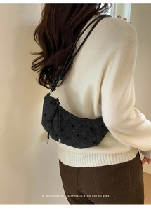 Elegante borsa a mezzaluna nera con trama intrecciata e discreto motivo a pois