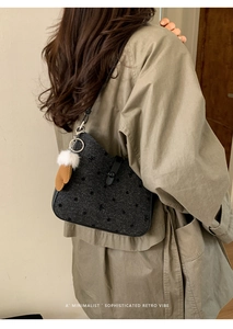 Close-up of retro black polka dot shoulder bag with leather strap and plush pendant charm