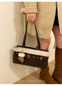 Detail of retro dark brown suede bag with faux fur trim and glove charm accessory