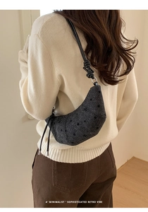 Détail de la texture grise à pois et du nœud sur la bandoulière en cuir du sac