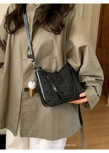 Close-up of retro black polka dot bucket bag with a white plush carrot pendant