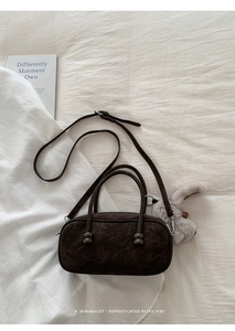 Detail of dark brown retro pillow bag with soft texture and plush rabbit charm