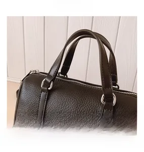 Close-up of black litchi pattern leather texture and silver metal hardware details