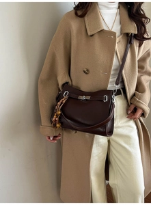 Detail of dark brown suede tote with silver metal buckle and vintage beaded tassel