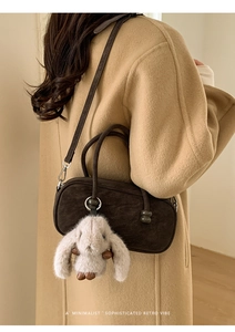 Detail view of a retro coffee brown bowling bag with a cute plush bunny charm