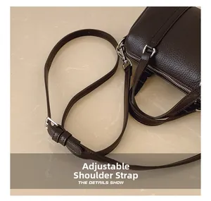 Detail of adjustable shoulder strap and silver hardware on dark brown leather bag