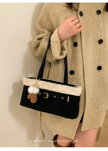 Detail of a retro black shoulder bag with faux shearling trim and a cute glove charm