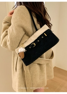 Detail of black faux suede shoulder bag with plush fleece trim and glove charm accessory