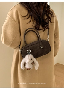 Deep brown suede retro handbag featuring a cute plush bunny charm and smooth metallic hardware