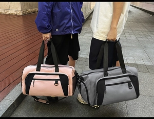 Close-up of pink and grey large capacity nylon travel bags with durable handles