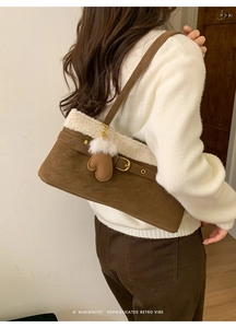 Detailed view of retro faux suede shoulder bag with plush shearling trim and glove charm