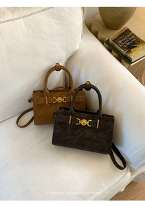 Detalle de bolsos retro de ante con hebillas de corazón doradas y asas dobles