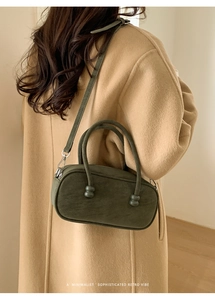 Deep green leather pillow bag shown with camel wool coat for minimalist retro style
