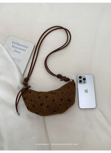 Vue détaillée du sac à pois marron avec bandoulière en cuir sur tissu crème