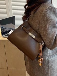 Deep brown matte leather tote bag with silver turn-lock and wooden beaded tassel