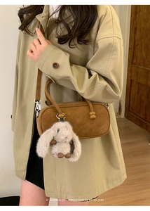 Retro brown suede bowling bag with wooden beads and a plush bunny charm on a coat