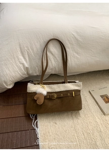 Detail of winter shoulder bag with brown suede finish and white plush faux fur trim