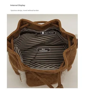 Detailed interior of suede bucket bag showing black and white striped lining and zipper pocket