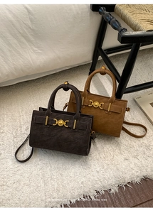 Detalle de bolsos bandolera retro en cuero marrón y canela con hebillas vintage