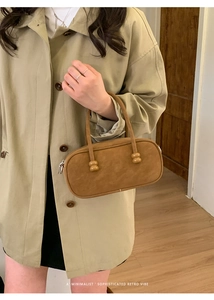 Close-up of minimalist retro brown suede pillow bag with elegant beaded handle details