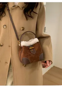 Détail du sac seau d'hiver en daim marron avec bordure élégante en fausse fourrure