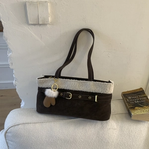 Detail of vintage brown suede shoulder bag with plush faux fur trim and glove charm