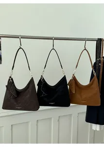 Detailed close-up of three hobo bags in coffee, black and brown with gold hardware