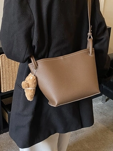Vintage dark brown leather crossbody bucket bag with cute bear charm and contrast stitching