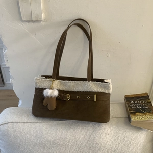 Detail view of brown faux suede tote bag with white faux fur trim and cute glove charm