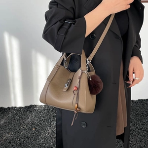 Détail du sac seau kaki avec cuir grainé et gland décoratif en fourrure et perles