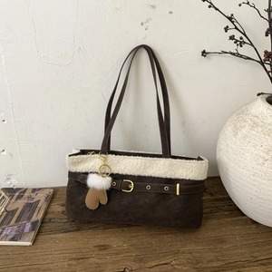 Detail of dark brown faux suede shoulder bag with plush shearling trim and cute charms