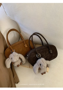 Close-up of suede retro handbags in caramel and coffee with cute bunny charms