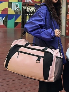 Pink and black large capacity travel bag with adjustable strap in outdoor street scene