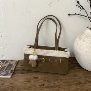 Winter brown suede shoulder bag with white plush trim and heart charm on wood table