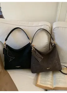 Detail of vintage tote bags in black and brown suede with stylish envelope pendant