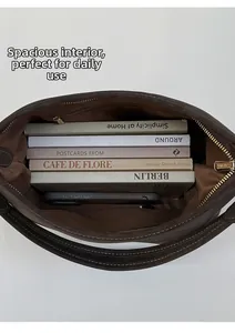 Macro view of spacious interior of dark brown tote bag holding books and smartphone