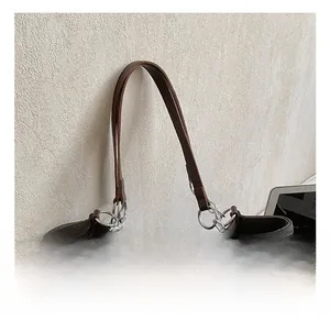 Detail of comfortable dark brown tote handle with stylish silver chain links and plush charm