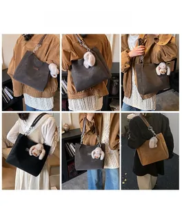 Detail view of large tote bag with chain strap and cute plush rabbit charm accessory