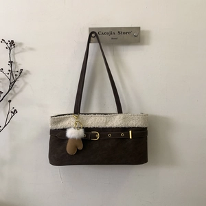 Detail of dark brown matte tote with cream faux fur trim and plush glove charm accent