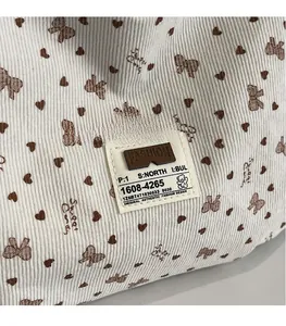 Détail du tissu en velours côtelé avec motifs de cœurs et étiquette de mode